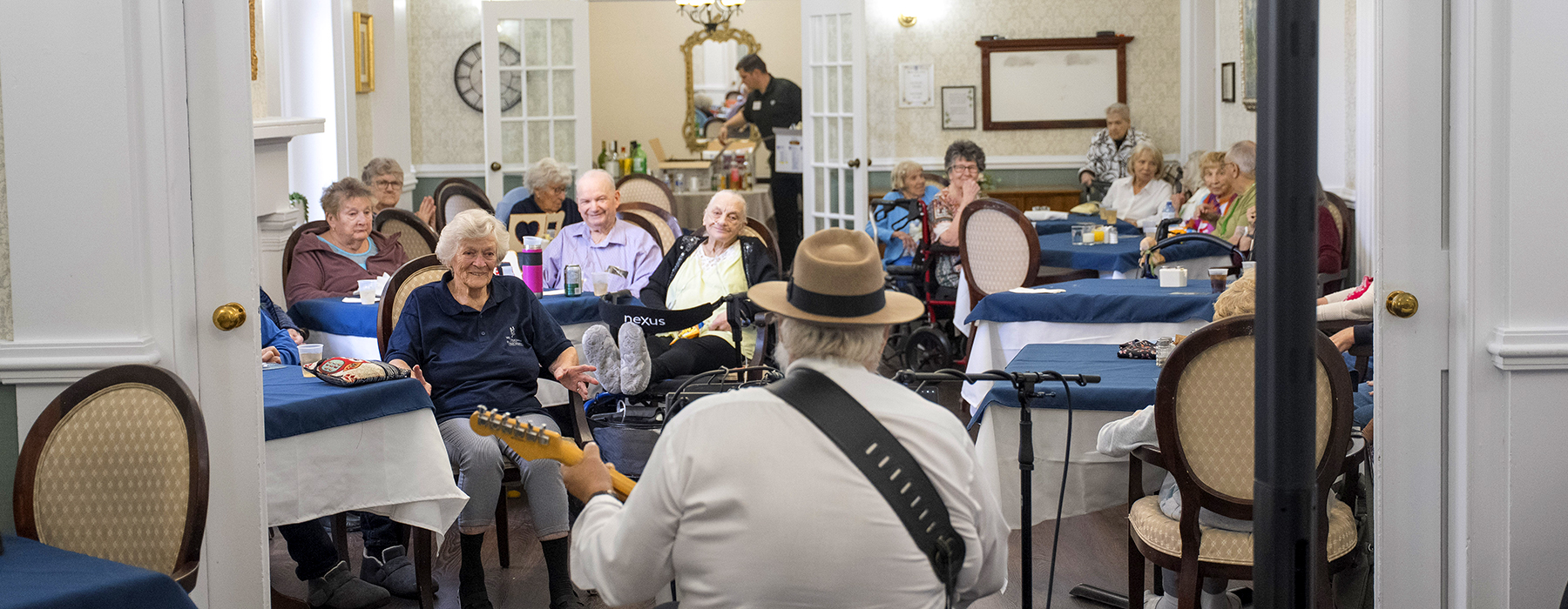 Entertainer playing guitar and singing for the Willoughby residents